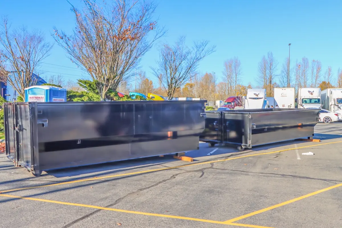 Professional dumpster rental service with roll-off container on residential driveway in North Greenbush